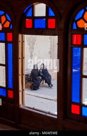 Kashan, Iran - 26. April 2017: Iranische Frauen in hijabs auf einer Bank sitzen auf dem Hof in Tabatabaei historischen Haus. Stockfoto