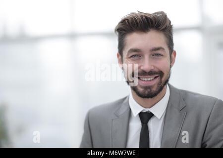 Glücklich, junger Mann in Anzug an Kamera suchen mit toothy Lächeln Stockfoto