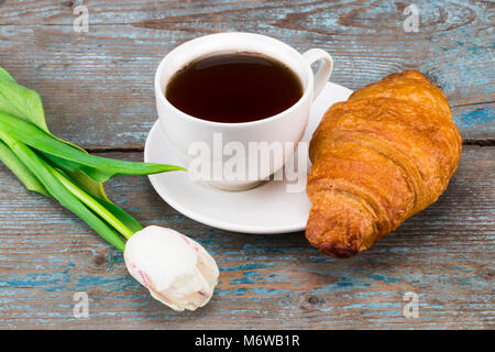 Tulpen und Tasse Kaffee und Croissant auf hölzernen Tisch. Ansicht von oben mit der Kopie. Stockfoto