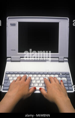 1994 historische womans Hände Eingabe über mechanische Tastatur der TOSHIBA T1910CS SATELLITE LAPTOP NOTEBOOK COMPUTER (© TOSHIBA CORP 1994) Stockfoto
