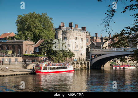 Ein Fluss Kreuzfahrt Schiff liegt in der Nähe von Lendal Tower (ehemals Teil der Yorks mittelalterliche Mauer Abwehr) und Lendal Brücke, Fluss Ouse, York, North Yorkshire, Großbritannien Stockfoto