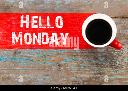 Text hallo Montag und Tasse aromatischen Kaffee auf Holz- Hintergrund, Nahaufnahme. Stockfoto