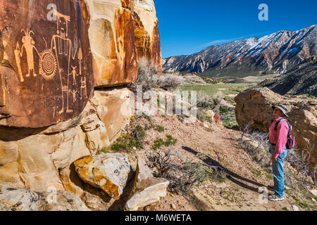 Wanderer bei McKee Federn Petroglyphen, Fremont Kultur, Split Berg im Hintergrund, Insel der Park Road, Dinosaur National Monument, Utah, USA Stockfoto