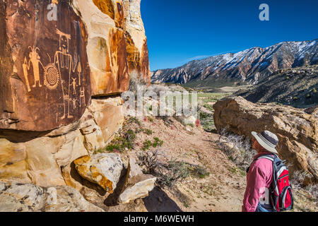 Wanderer bei McKee Federn Petroglyphen, Fremont Kultur, Split Berg im Hintergrund, Insel der Park Road, Dinosaur National Monument, Utah, USA Stockfoto