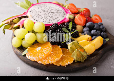 Exotische Früchte Platte mit Trauben, Drachenfrucht, Pfirsich und Beeren Stockfoto