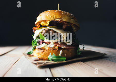 Appetitlich Cheeseburger auf hölzernen Tisch. Stockfoto