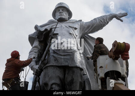 Arbeitnehmer malen ein Denkmal eines Soldaten Befreier in Weiß vor dem Gedenken an den Tag des Sieges in Moskau, Russland Stockfoto