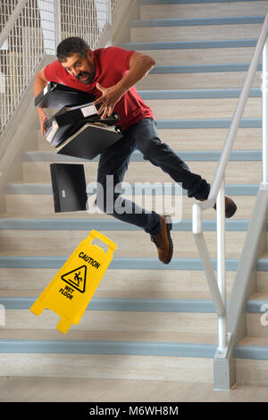 Hispanische Arbeiter tragen Dateien fallen auf nassen Treppen Stockfoto