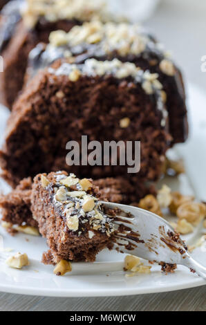 Schokoladenkuchen, in Scheiben geschnitten, mit Kokos und Nussbaum abgedeckt. Stockfoto