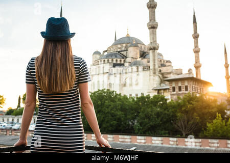 Ein junger Tourist Mädchen mit einem schönen Bild sieht von der Terrasse des Hotels auf der ganzen Welt berühmten Blauen Moschee Sultanahmet in Istanbul, Türkei. Reisen, sig Stockfoto