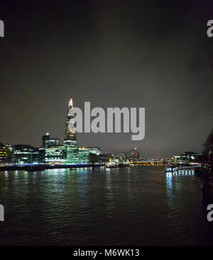 Der Shard und HMS Belfast in der Nacht über den Fluss mal angesehen und die Lichter der Stadt auf dem Wasser widerspiegeln. Stockfoto