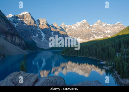 Nachmittag Licht auf die schneebedeckten Gipfel der Umgebung die atemberaubende Moraine Lake, Alberta, Kanada. Die Berge sind in vibrant blue Gletscherwasser wider. Stockfoto