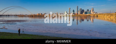 Dies ist das Bild eines Fotografen unter Bild der Skyline von Dallas bei sunett mit Reflexion über Trinity River, Dallas, Texas. Stockfoto