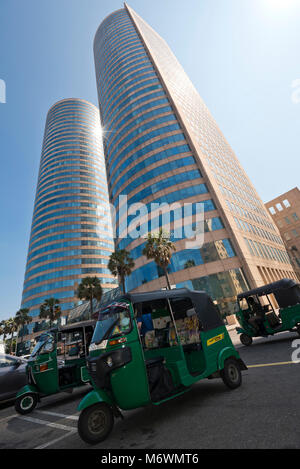 Vertikale Sicht auf das World Trade Center Gebäude in Colombo, Sri Lanka mit Rikschas draußen auf der Straße geparkt. Stockfoto