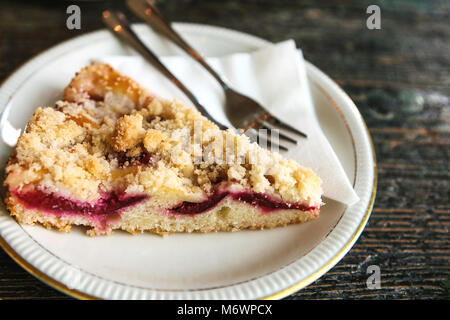 Stück süße Torte mit Dessert Gabel auf einem Teller auf einem hölzernen Oberfläche im Cafe Stockfoto