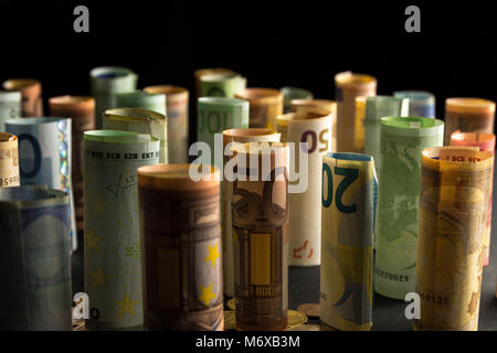 Geld Euro-Münzen und -Banknoten in Rollen Stockfoto