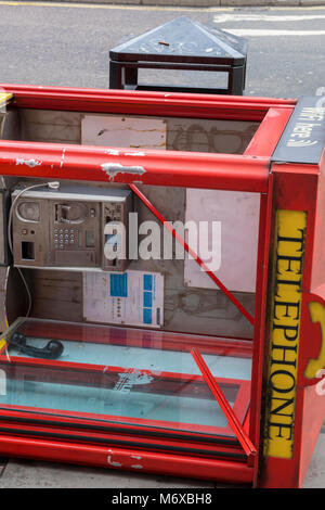 In einem alten roten Telefon Münzautomaten card Phone Call-Box auf die Seite über an der Seite des Londoner Straße gefallen. Veraltet und redundante Tech. Stockfoto