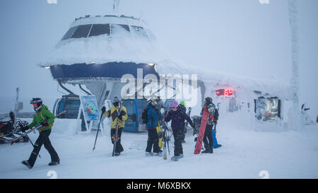 Skifahrer und Snowboarder aussteigen aus einer Gondel im Skiort Levi in Finnland Stockfoto