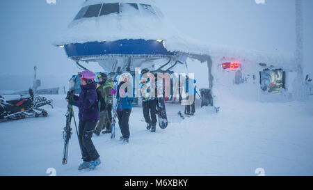 Skifahrer und Snowboarder aussteigen aus einer Gondel im Skiort Levi in Finnland Stockfoto