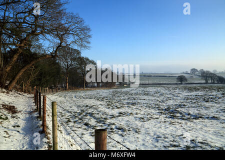 Blick auf Fußweg und Zaun Begrenzung zu schneebedeckten Feld am Ortsrand von Brabourne Lees in der Nähe von Ashford, Kent, Vereinigtes Königreich Stockfoto