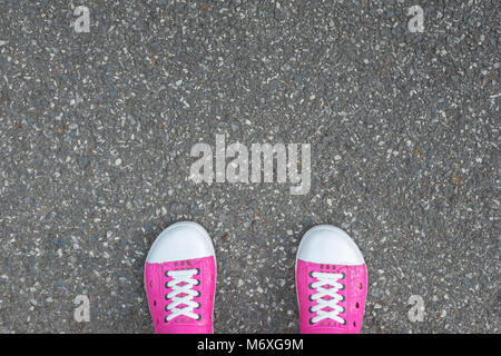 Rosa Schuhe stehen auf Asphalt Betonboden Stockfoto