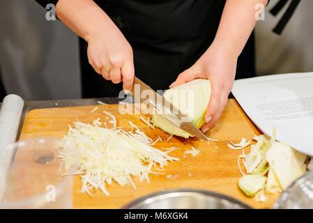 Frau hacken Kohl auf dem hölzernen Schneidebrett Stockfoto