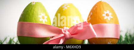 Drei Ostereier in rosa Schleife verpackt Stockfoto