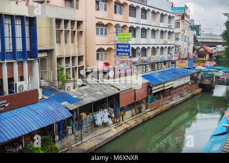 BANGKOK, THAILAND - 20.Februar 2015: Eher armen Viertel und den Kanal fließt. In Bangkok, können Sie oft sehen die Häuser stehen gerade über t Stockfoto