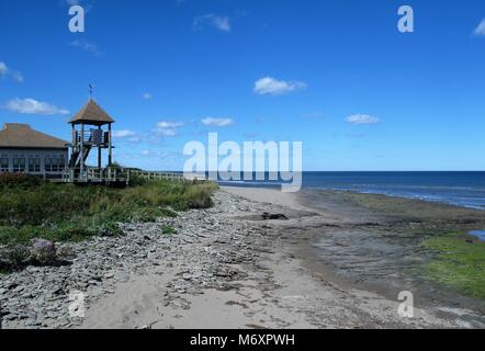 Hölzerne Aussichtsturm auf einem felsigen Strand am Meer Stockfoto