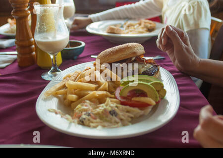 Hamburger mit Pommes auf dem Tisch als Teil der Familie Abendessen in einem Restaurant Stockfoto