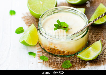 Mini lime Cheesecake in einem Glas Topf auf weißem Holz- Hintergrund Stockfoto