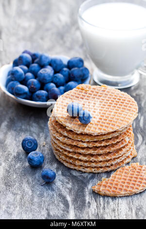 Stapel von Niederländischen karamell Waffeln mit Heidelbeeren und Tasse Milch Stockfoto