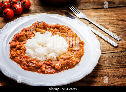 Traditionelle indische Küche. Spicy Tikka Masala mit Reis auf Holz Tisch Stockfoto