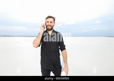 Kleidung Designer über Smartphone mit Bruder zu kommunizieren Stockfoto
