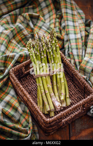 Blumensträuße frischer Spargel im Weidenkorb auf rustikalen Hintergrund Stockfoto