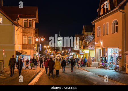 Karpacz, Polen - Februar 2018: Touristen zu Fuß auf der Hauptstraße in Karpacz Stadt, polnische Winter Skigebiet Stockfoto