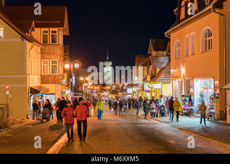 Karpacz, Polen - Februar 2018: Touristen zu Fuß auf der Hauptstraße in Karpacz Stadt, polnische Winter Skigebiet Stockfoto