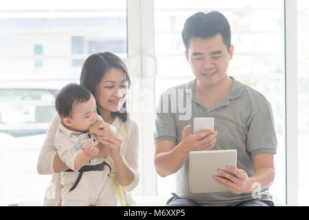 Chinesischer Mann scannen QR Code mit Smart Phone. Asiatische Familie zu Hause, Natural Living Lifestyle im Innenbereich. Stockfoto