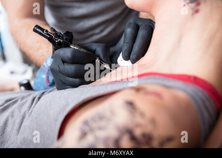 Nahaufnahme der Hand einer Tattoo artist tattooing 2 Rosen Stockfoto