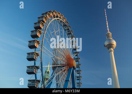 Ein Riesenrad am Neptunbrunnen mit der Fernsehturm (Fernsehturm) in Alexanderplatz, Mitte, Berlin, Deutschland Stockfoto