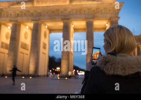 Ein Tourist, der ein Bild auf Ihrem Handy am Brandenburger Tor, Mitte, Berlin, Deutschland Stockfoto