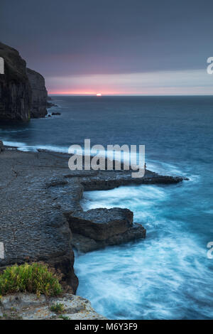 Einen einsamen Angler auf Dancing Ledge in der Morgendämmerung, Jurassic Coast, Dorset, England, Großbritannien Stockfoto