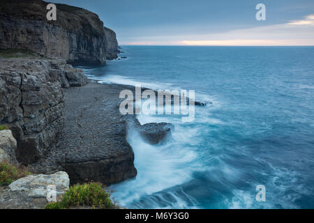 Einen einsamen Angler auf Dancing Ledge in der Morgendämmerung, Jurassic Coast, Dorset, England, Großbritannien Stockfoto