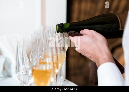 Kellner gießt Champagner Stockfoto