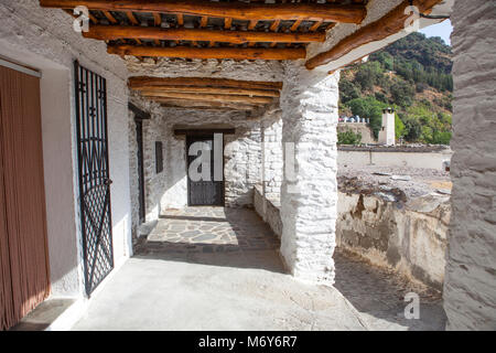 Traditionelle Gasse namens Amador Gil. Einzigartige Architektur, Gebäude auf beiden Seiten der schmalen Straßen des Ortes verbindet. Capileira Stadt. Alpujarra Stockfoto