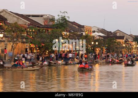 Die Dämmerung fällt auf Bach Dang Street Touristen zu Boote auf dem Thu Bon Fluss nehmen, um die Aussicht zu genießen. Stockfoto