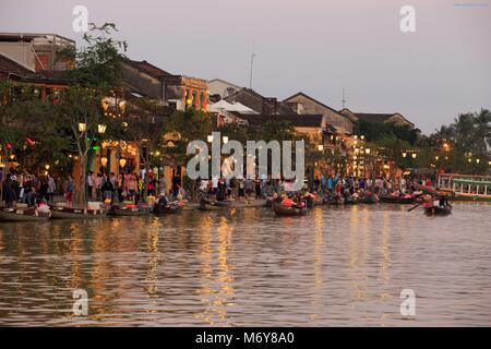 Die Dämmerung fällt auf Bach Dang Street Touristen zu Boote auf dem Thu Bon Fluss nehmen, um die Aussicht zu genießen. Stockfoto