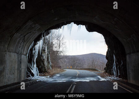 Eis auf der Straße! . Haben Sie an der Mündung der Höhle stehen? Gut...Nr. Dieses Bild ist aus dem Inneren von Mary's Rock Tunnel. Diese stalaktiten sind von Wasser gemacht, und diese Höhle ist ein Tunnel im Jahr 1932 gestaltete, ein Meisterstück der Technik betrachtet. Oh. Sie sehen, dass sich Eis auf der Straße da unten? Es ist eine Mahnung zur Vorsicht beim Fahren Skyline Drive im Winter. Stockfoto