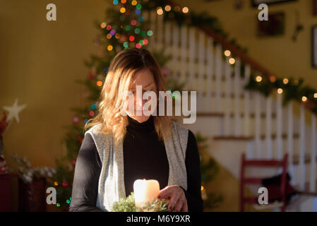Nahaufnahme von Frau mittleren Alters home Dekoration für Weihnachten im hellen Morgen Sonnenlicht Stockfoto