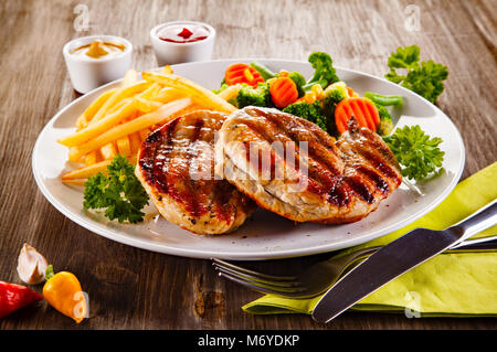 Gegrillte Steaks, Pommes frites und Salat Stockfoto